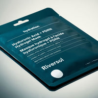 Riversol Hyaluronic Acid + PDRN Hydrogel Mask in a dark teal resealable pouch, photographed at an angle on a light gray background.