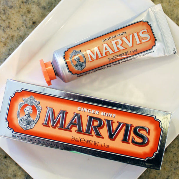 Two tubes of Marvis toothpaste, travel size, placed on a surface. One tube is in front, and the other is partially visible in the background.
