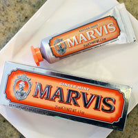 Two tubes of Marvis toothpaste, travel size, placed on a surface. One tube is in front, and the other is partially visible in the background.