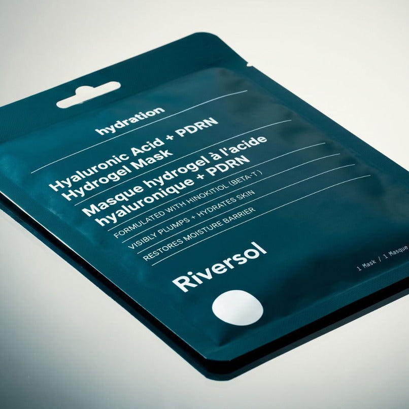 Riversol Hyaluronic Acid + PDRN Hydrogel Mask in a dark teal resealable pouch, photographed at an angle on a light gray background.
